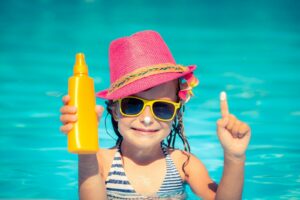 bigstock child holding sunscreen lotion 183796519