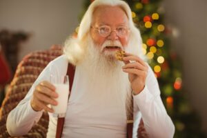 bigstock smiling santa claus eating a c 77767595