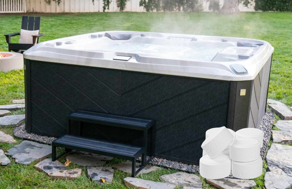 a photo of a hot tub in a yard with green grass. there are grey and brown patio stones beneath the spa and surrounding it, and a set of dark steps leading up to the hot tub. there is a pile of sanitizer tablets in the right side of the picture.